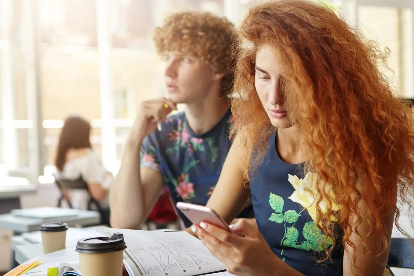 Junge Studentin hält ein Smartphone und sucht im Internet nach Informationen.