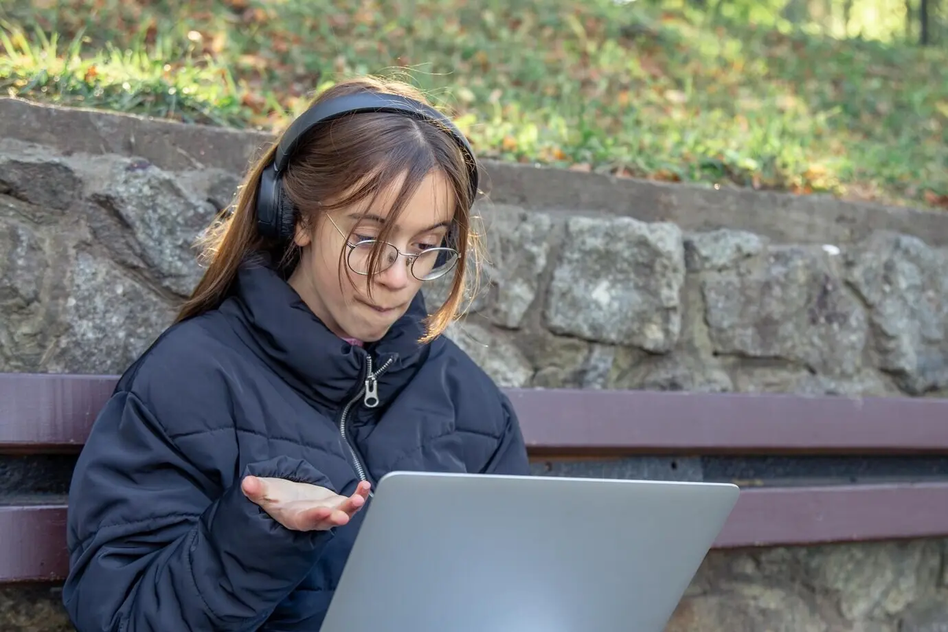 Ein Mädchen mit Kopfhörern arbeitet am Laptop. Ein Mädchen mit einem Laptop.
